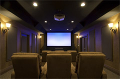 Dedicated home theater with a projection screen and rows of seating